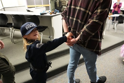 little girl with a police officer and handcuffs 